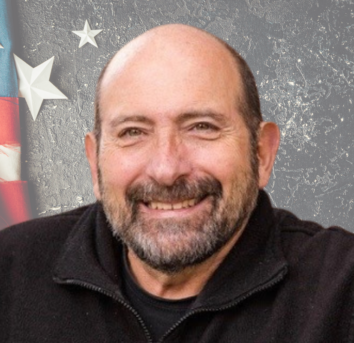 Jim Pantela with a patriotic background of stars and stripes