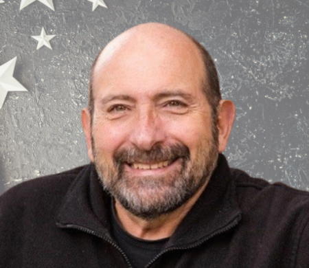 Headshot of Jim Pantelas with a stars and stripe background.