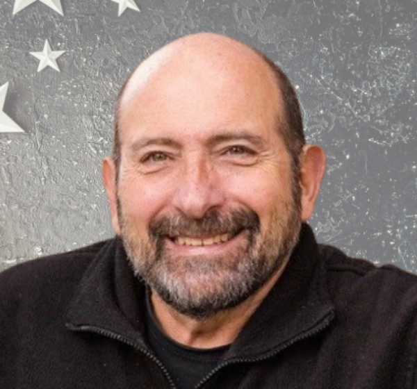 Headshot of Jim Pantelas with a stars and stripe background.